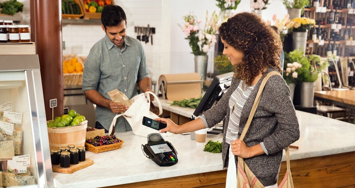 Mulher pganado em com Android Pay via NFC em maquina de cartao